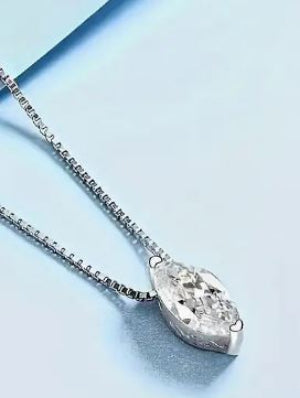 Silver necklace with a teardrop-shaped pendant on a light blue background