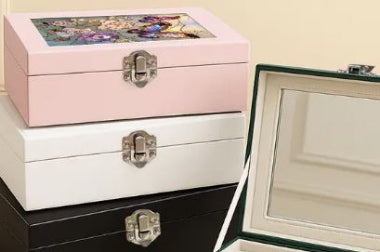 Three jewelry boxes in pink, white, and black with floral and mirror designs.